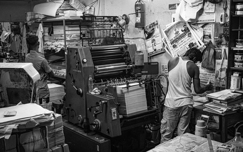 Print shop floor with printing equipment and finished materials